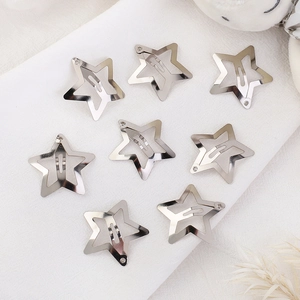 Set of 8 silver star-shaped metal hair clips with minimalist hollow design on fabric