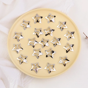 Detailed macro view of 18 silver star-shaped metal hair clips in a decorative ceramic bowl