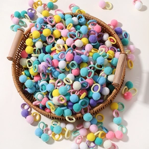 Colorful pom-pom hair ties set for girls in a woven basket with macaron fuzzy balls