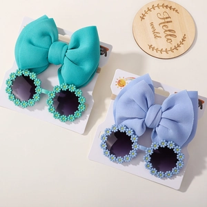 Detail of baby nylon headband bow and daisy flower sunglasses in mint and lilac colors