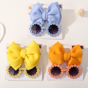 Detailed set of daisy sunglasses and bow headbands for girls in blue, yellow, and orange