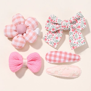 Detail of 5-piece pink floral baby girl hair clip set with bows and fabric flowers