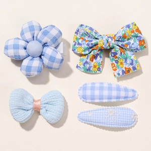 Detail of five-piece set featuring blue floral bows and fabric hair clips for baby girls
