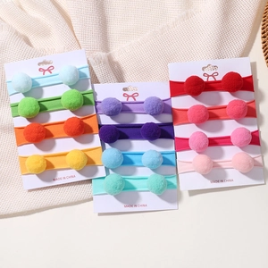 Vue détaillée du lot de 12 bandeaux à pompons pour bébés sur cartes de support