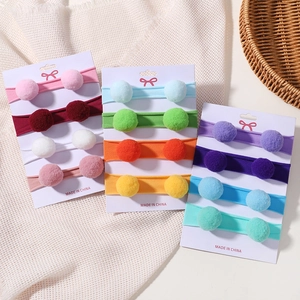Gros plan de bandeaux pour bébé en nylon avec pompons en peluche colorés sur cartes