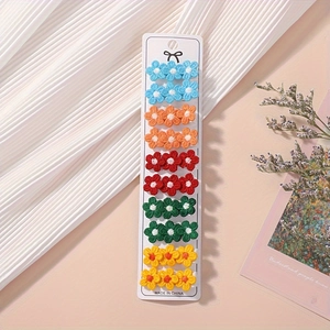 Set of ten floral knit hair clips in five colors displayed on a white paper board