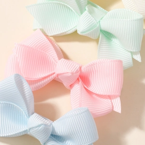 Gros plan détaillé de nœuds papillon en ruban gros-grain pour filles aux tons pastel