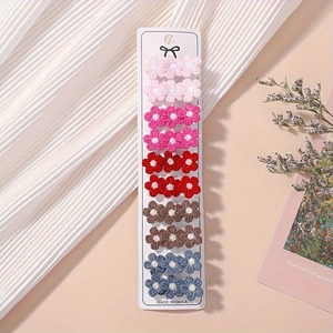 Detailed set of 10 embroidered floral hair clips displayed on a white branded card