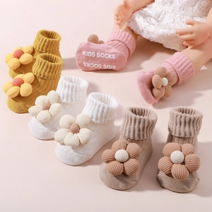 Detail von Babysocken mit 3D Stoffblumen und rutschfester Gummibeschriftung auf der Sohle