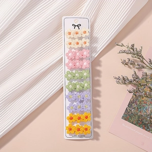 Detailed close-up of 10-piece embroidered floral hair clips set on display card
