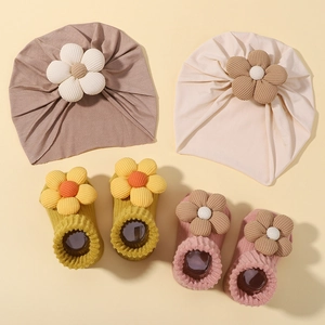 Detailansicht von Baby-Turban-Mützen und Anti-Rutsch-Socken-Set mit 3D-Blumenakzenten