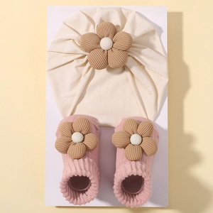 Detailansicht von Baby-Mütze und Socken-Set mit süßen Cord-Blumendekorationen