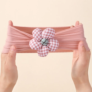 Detail of high elasticity baby headband with soft pink knit fabric and plaid flower decor