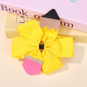 Détail d'un nœud papillon en forme de crayon fait de ruban gros-grain jaune pour les enfants
