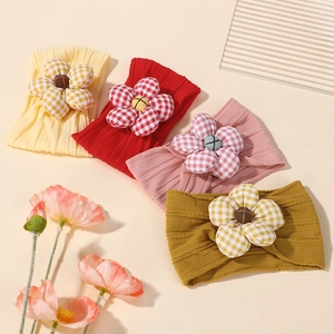 Four-piece set of soft elastic baby headbands with large fabric flowers in multiple colors