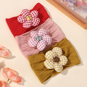 Three-pack soft baby headbands with large checkered fabric flowers and ribbed texture