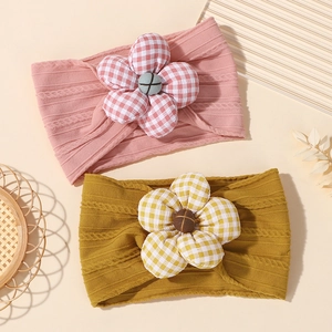 Detail of baby nylon headbands with large checkered fabric flowers and knit texture