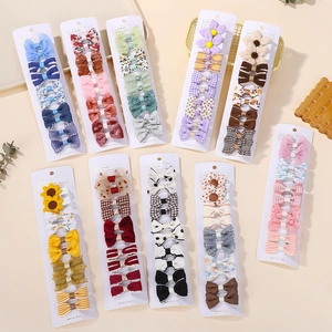Flat lay detail of assorted colorful handmade kids hair clips with plaid and floral patterns