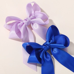 Detail of lavender and royal blue handmade ribbon bows with smooth satin texture