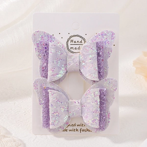 Détail de barrettes papillon en dentelle violette faites à la main avec des paillettes