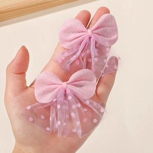 Detailed close-up of pink sequin bow hair clips with polka dot mesh for girls