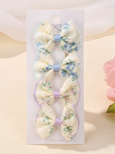 Close-up of 4-piece set of floral lace bow hair clips for kids on a paper card