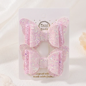 Vue détaillée de pinces à cheveux papillon rose pailleté avec dentelle sur carte de présentation