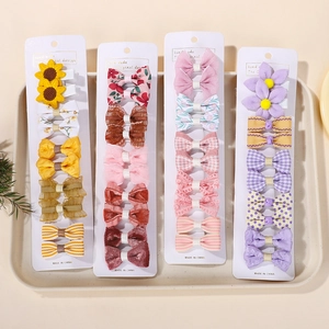 Detailed close-up of cute children's hair clip sets with bow and flower designs