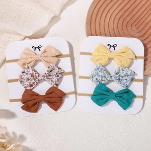 Lot de 6 bandeaux bébé en lin avec nœuds floraux et couleurs unies sur un plateau