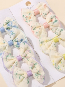 Detail showing 6-piece embroidered lace floral bow clips on white display cards