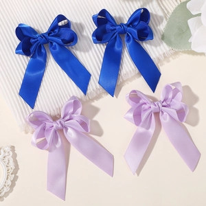 Close-up of navy and lavender satin ribbon bows with elegant long tails and silky texture