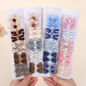 Close-up of assorted kids hair clips featuring plaid patterns, lace bows, and plush flowers