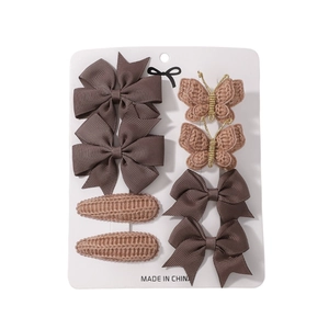 Set of 8 brown hair clips with ribbon bows and handmade crochet butterflies on display card