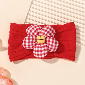 Détail d'une fleur en vichy rouge sur un bandeau élastique en nylon pour bébé