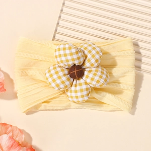 Détail du bandeau élastique jaune en nylon avec une fleur en tissu à carreaux jaune et blanc