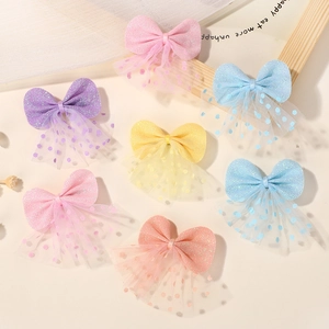 Detail of 7-piece sequined mesh bow hair clips in pastel colors with polka dot tulle fabric