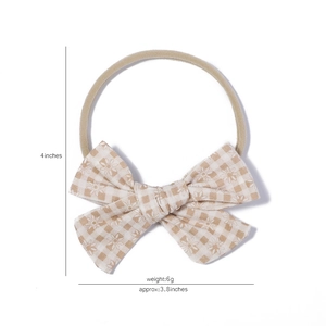 Detail showing baby nylon headband with beige floral bow and dimension marks