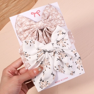 Détail de nœuds papillon à motif floral sur une carte de présentation blanche