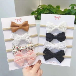 Detailed view of 8-piece baby bow headband set with nylon bands on display cards