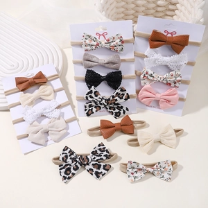 Assorted baby bow headbands in nylon, floral, and corduroy styles for newborns
