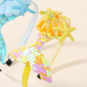 Detail of mermaid tail hairband with shiny sequins, glitter star and seashell decor