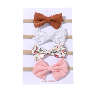 Set of 4 baby bow headbands including floral, lace, and faux leather designs on nylon bands