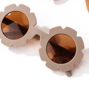 Gros plan sur des lunettes de soleil enfant en forme de fleur kaki mat avec verres