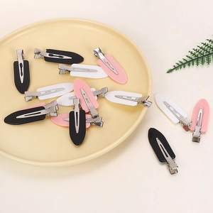 Detail of candy-colored matte alligator hair clips in black white and pink on a tray