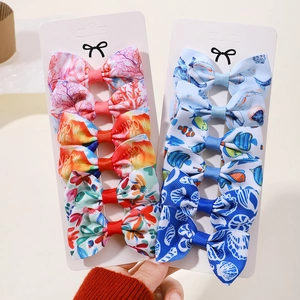 Détail de 12 barrettes à nœuds avec motifs océan et arc-en-ciel sur cartes