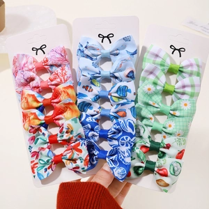 Détail d'un lot de 15 barrettes à nœuds pour filles aux motifs floraux et fruités colorés