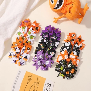 Detail of Halloween grosgrain ribbon hair bows with festive pumpkin and ghost patterns