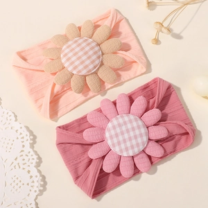 Détail de bandeaux souples pour bébé en nylon avec grandes fleurs texturées et centre à carreaux
