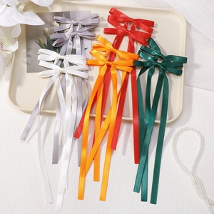 Cinque colori di eleganti fermagli per capelli a fiocco in raso con nappe in un vassoio