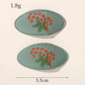 Détail de pinces à cheveux BB brodées vert sauge avec marquages de 5,5 cm de long